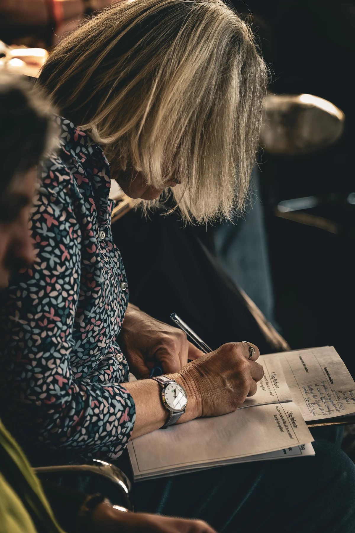 Teilnehmerin macht konzentriert Notizen während eines Seminars
